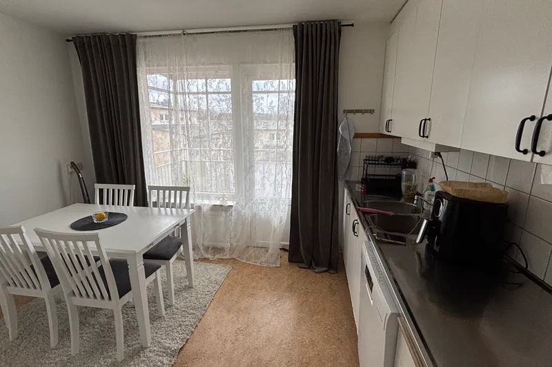 Ljus matplats vid fönstret med vita stolar